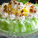 Grandma’s Lime Green Jello Salad with whipped topping and crushed pineapple, served in a vintage glass dish.