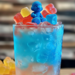 Drunken Papa Smurf Cocktail with a vibrant blue hue, served in a tall glass with a cherry garnish.
