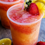 Vodka Strawberry Lemonade Slush served in a chilled glass with fresh strawberries and lemon slices.