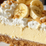 Banana Pudding Cheesecake with a vanilla wafer crust, creamy banana-flavored filling, and whipped topping.