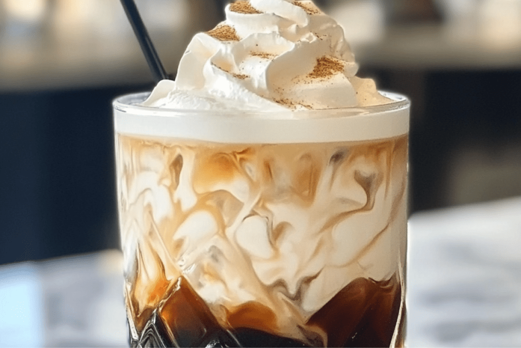 Vanilla Bean White Russian cocktail served over ice with a creamy swirl and a dusting of vanilla bean specks.
