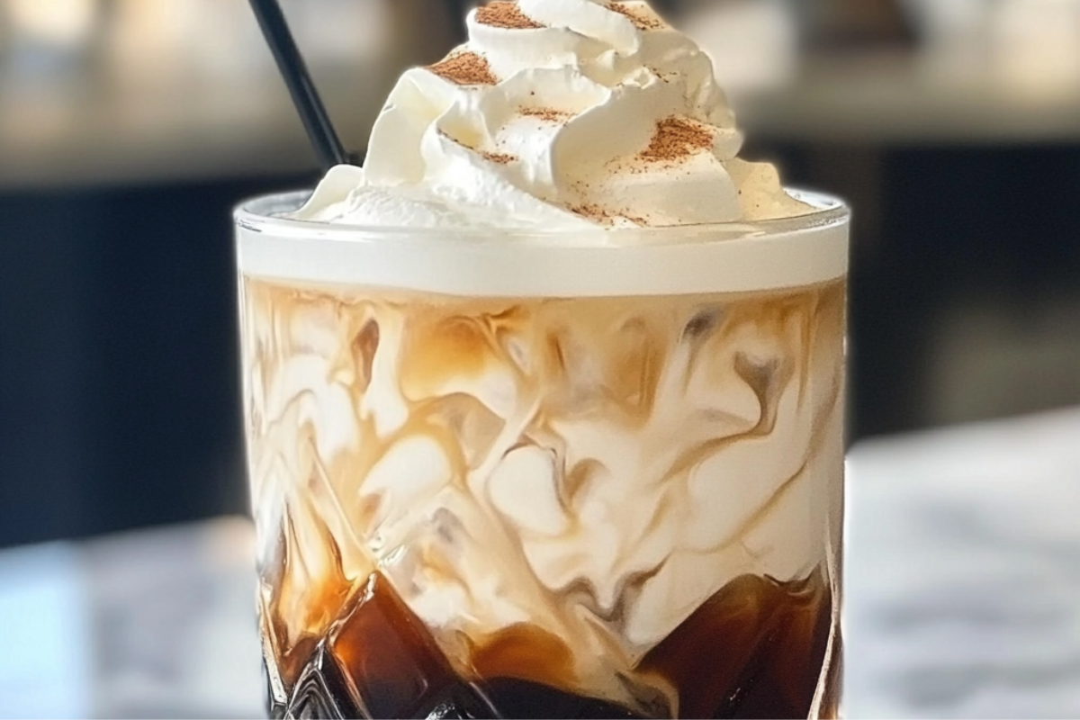 Vanilla Bean White Russian cocktail served over ice with a creamy swirl and a dusting of vanilla bean specks.