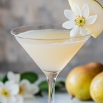 Elderflower Pear Martini served in a chilled martini glass, garnished with a thin pear slice and fresh herbs.
