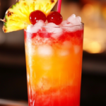 Punch Drunk Love Cocktail with a vibrant red hue, served over ice and garnished with berries and a citrus twist.
