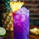 Jamaican Purple Rain Cocktail with a deep purple hue, served over ice and garnished with lime and cherries.